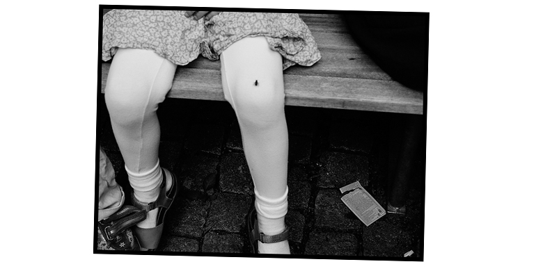 Photograph of the artist's daughter Filippa sitting on a bench with a small fly resting on her leg