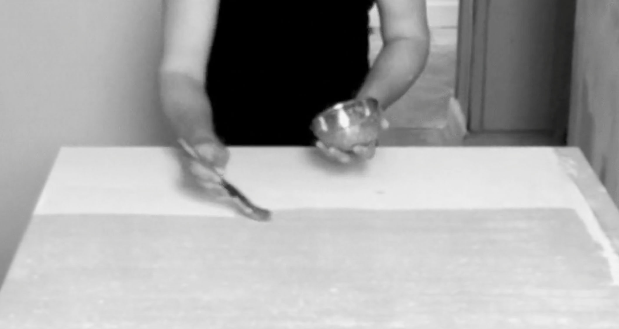 Video still showing fresh egg white being applied with a brush to the dry mineral surface
