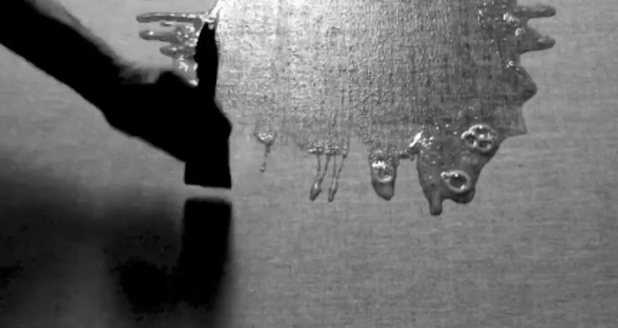 Video still showing a layer of fresh egg white being brushed over the surface of the mounted linen