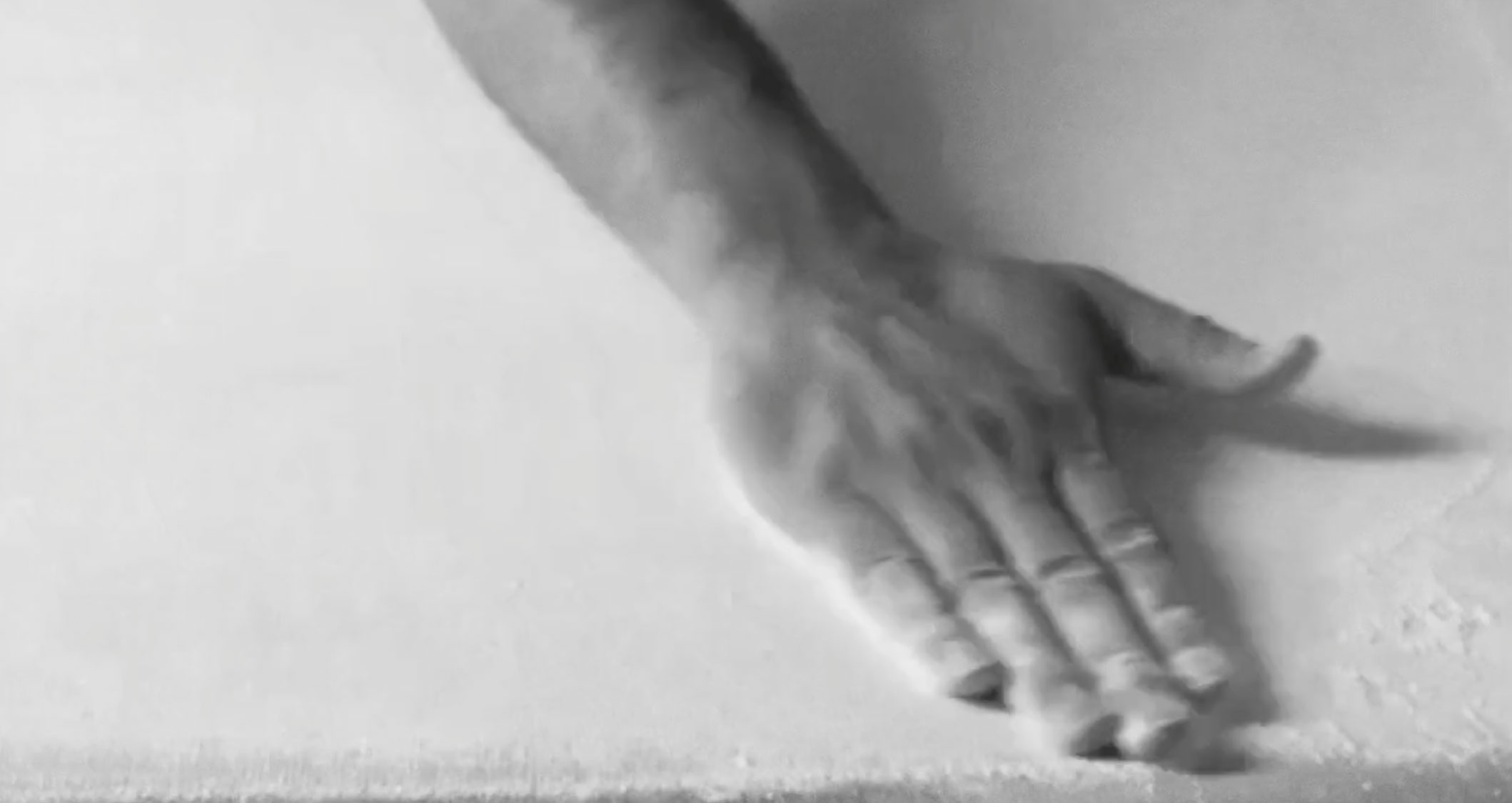Video still showing excess loose powder being removed by hand
