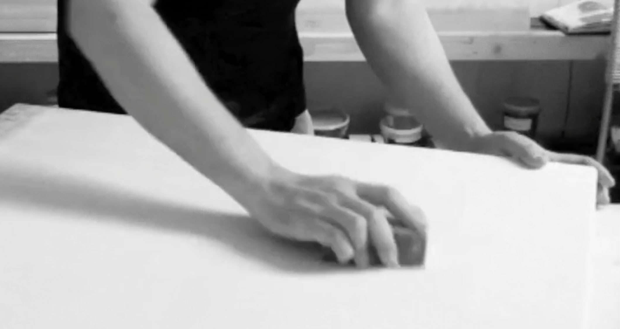 Video still showing the dried surface being lightly sanded with fine-grain sandpaper